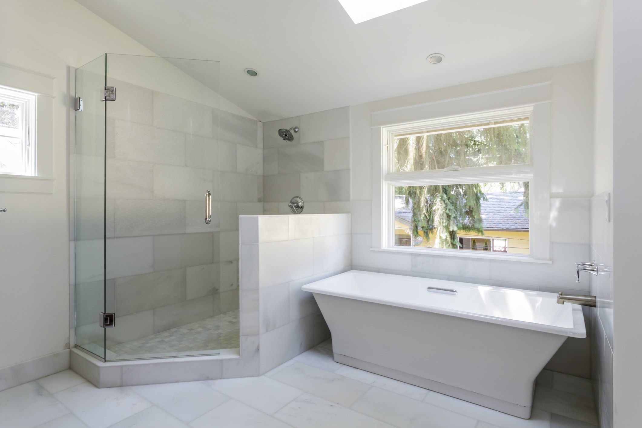 a new bathroom renovation with glass shower and freestanding bathtub